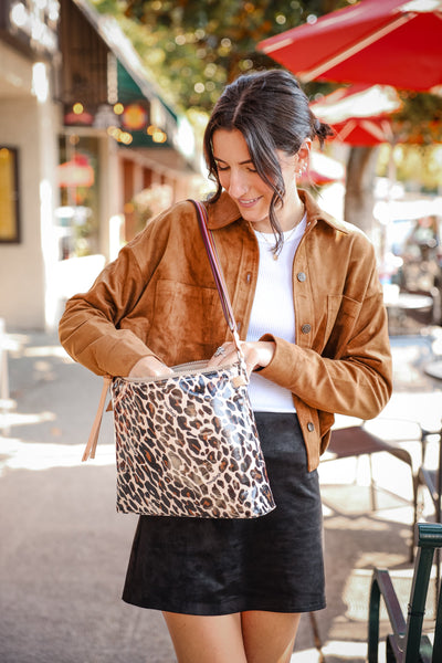 Bags and Wallets Collection for Women at Vixen Collection in Seattle WA | Woman in black pants holding two bags.