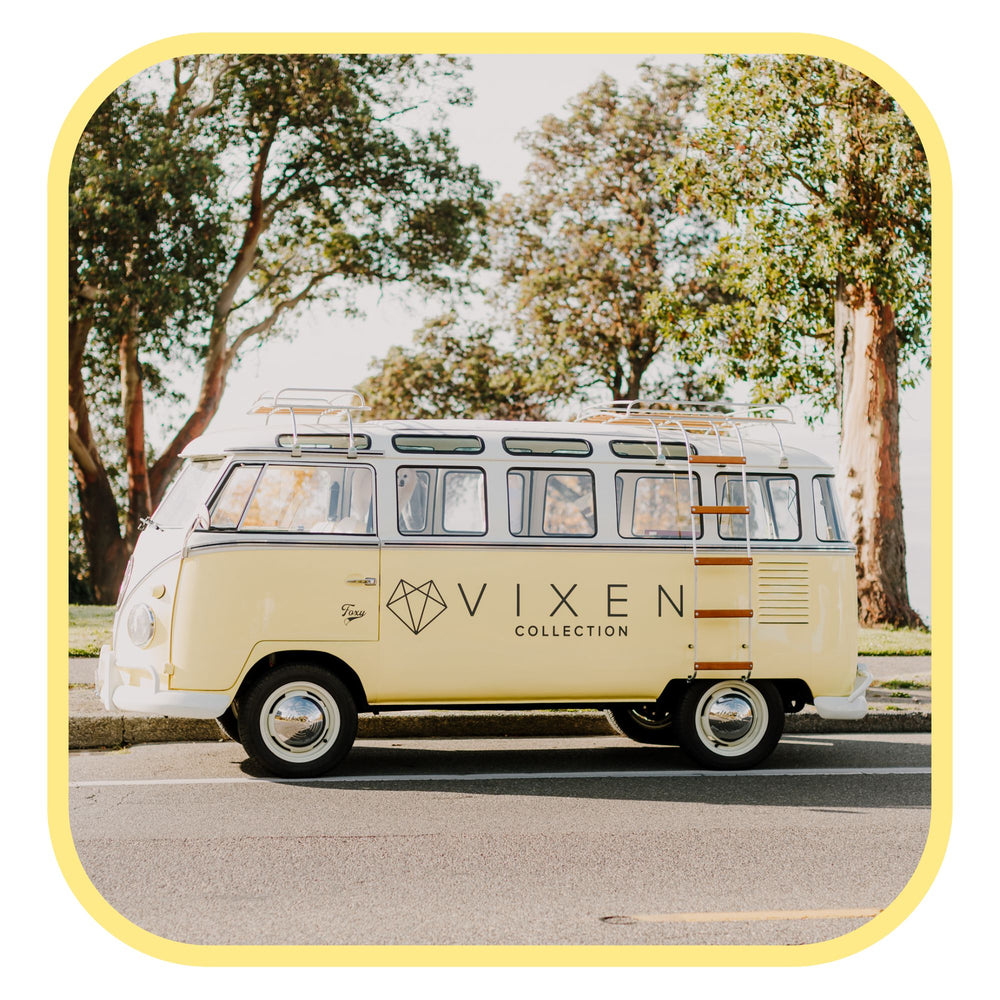 Vintage-style van with 'Vixen' branding on a scenic road.