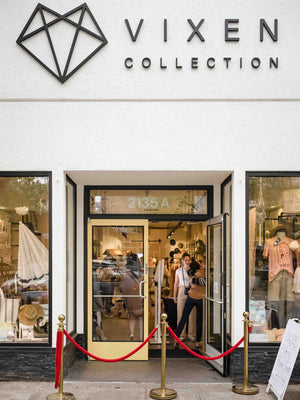 Storefront of Vixen Collection with glass doors and mannequins inside.