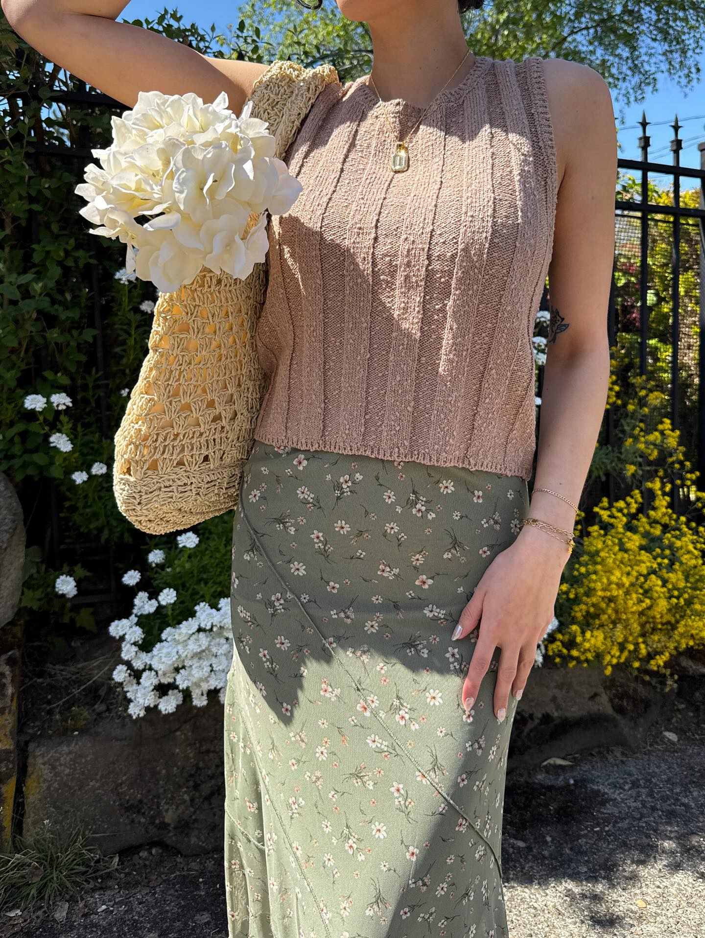 Floral landscape background with a girl carrying a woven bag with a bouquet in it.