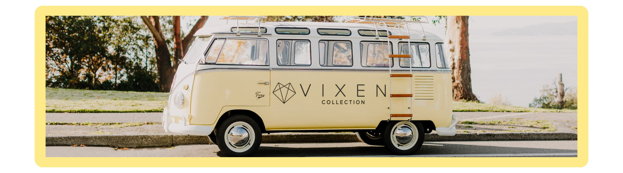 Vintage-style van with 'Vixen' branding on a scenic road.