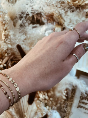 A woman's wrist wearing permanent jewelry. Now available at Vixen Collection Boutique in Seattle, WA. 